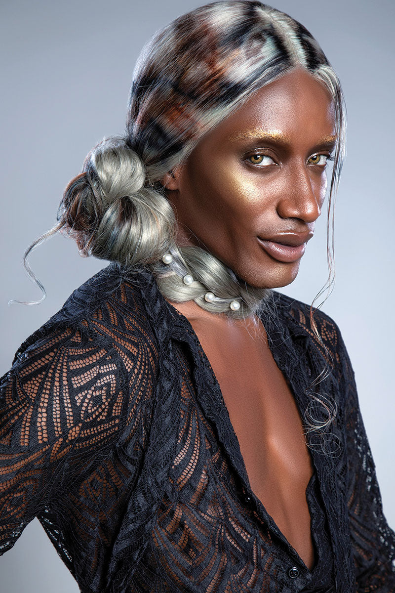 model in black mesh shirt with white blonde wig with black and brown painted patterns