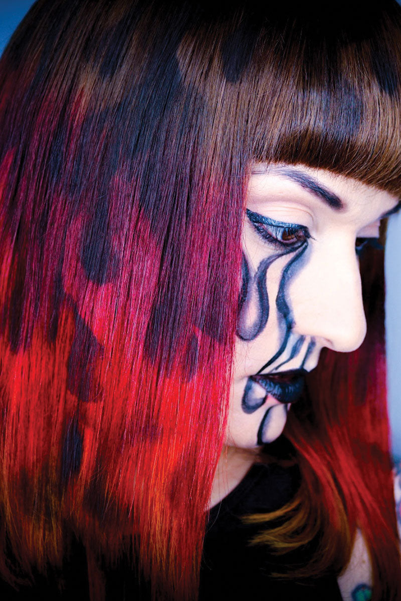shannon wearing a black brown red and orange wig with patterns that look like spray painted flames