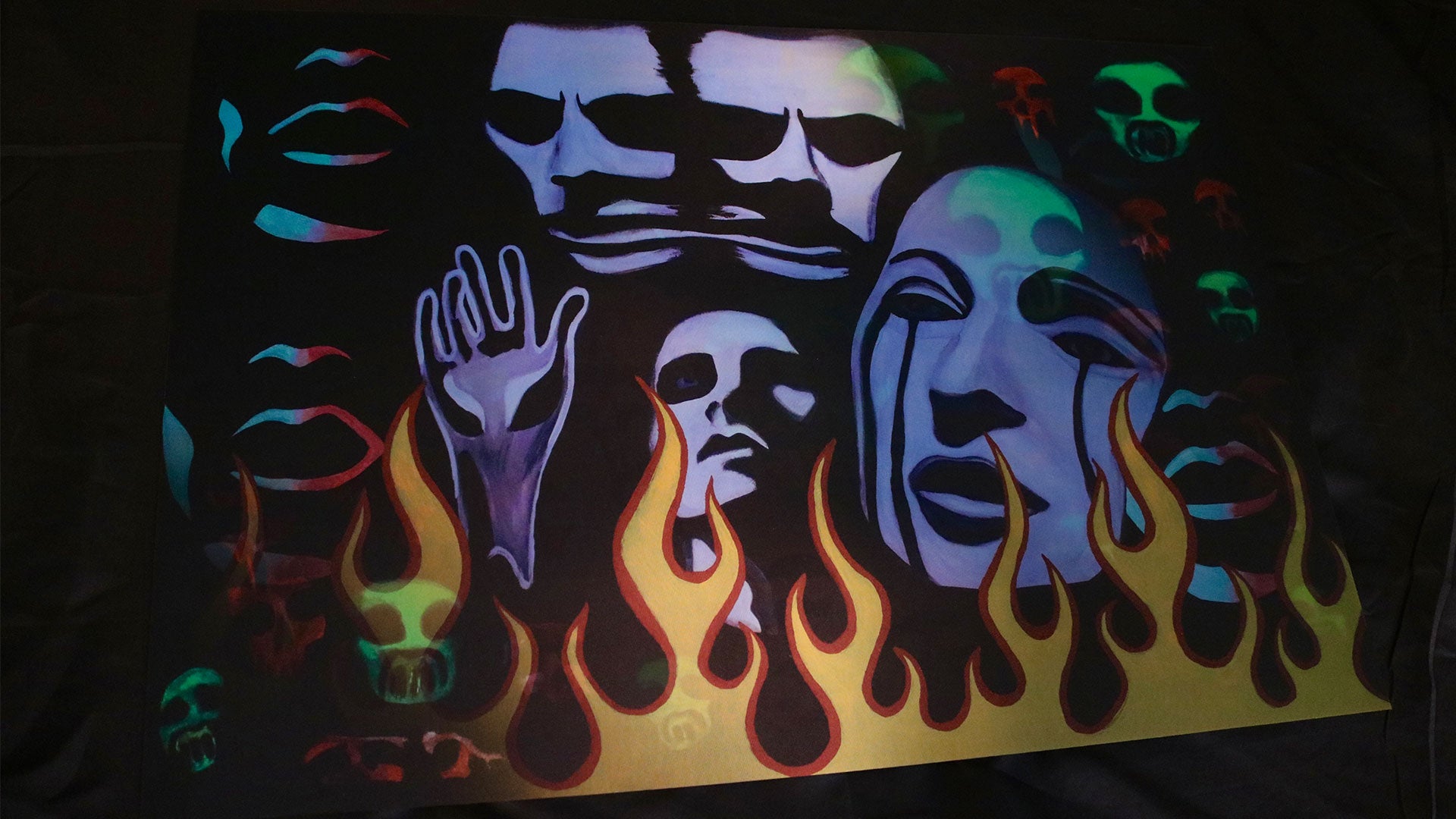 Glowing abstract design with faces and flames on a dark background