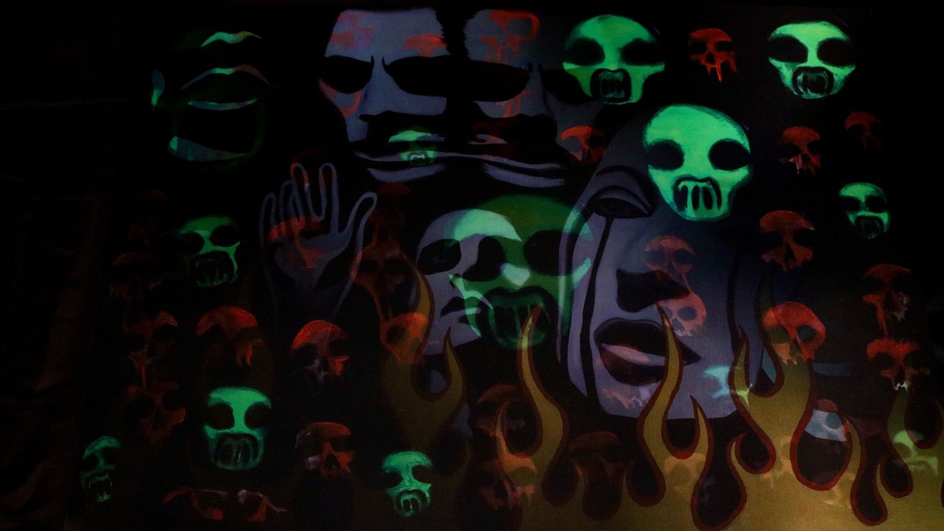 Glowing multicolored skulls on a dark background