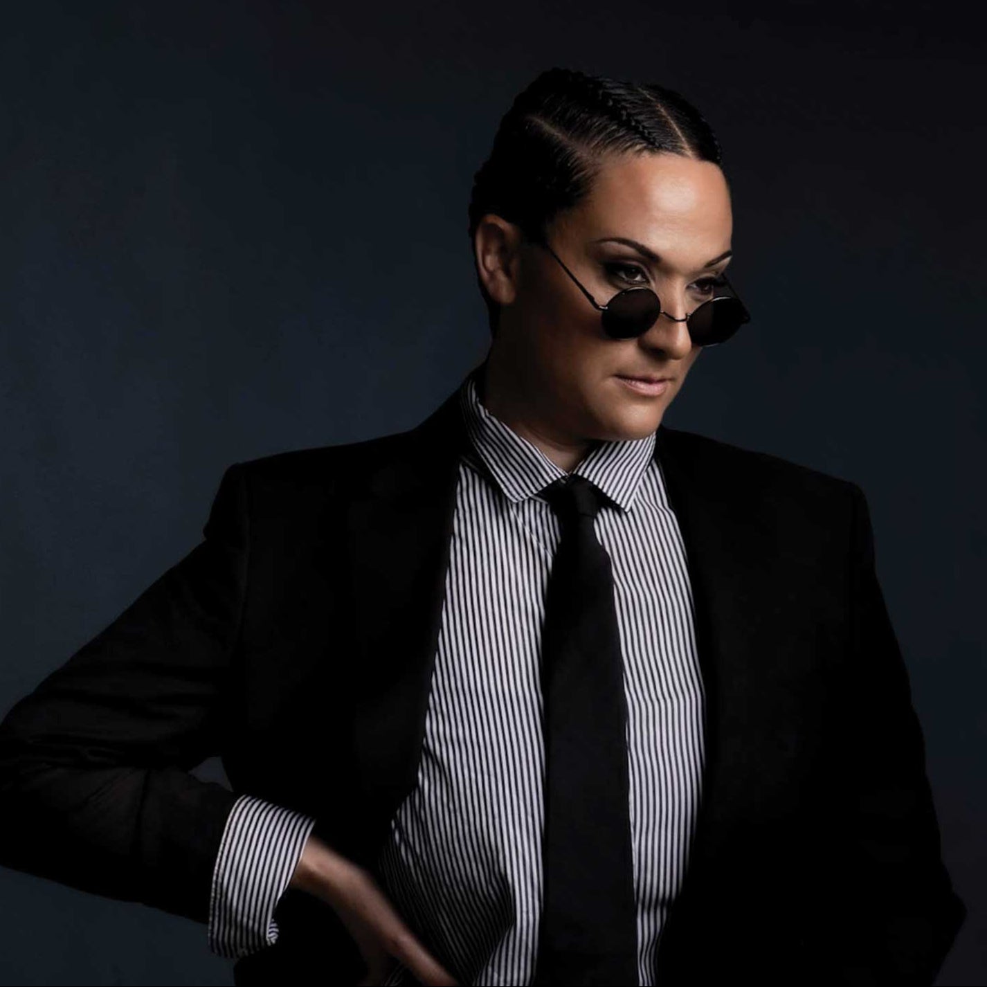 an image of shannon wearing a suit, tie, and sunglasses
