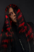 a model wearing black in a black and red skull wig