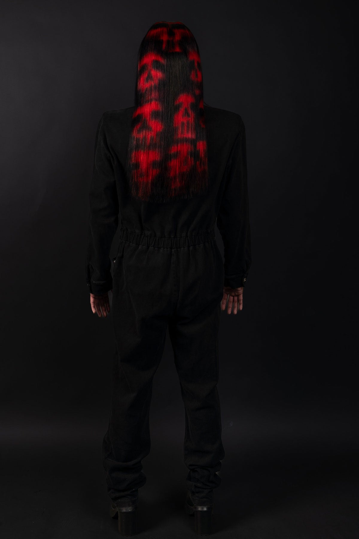 a back view of a model wearing black in a black and red skull wig