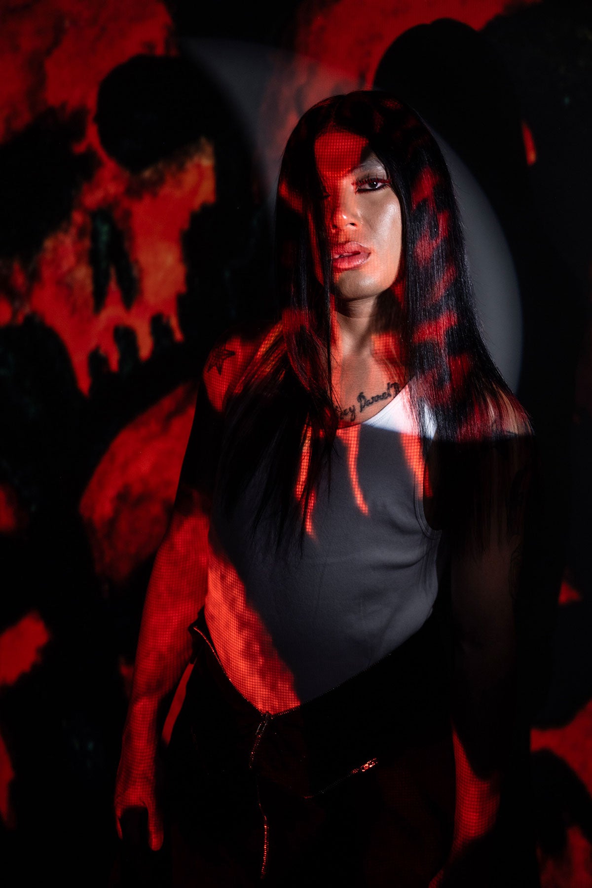 a model wearing black in a black and red skull wig