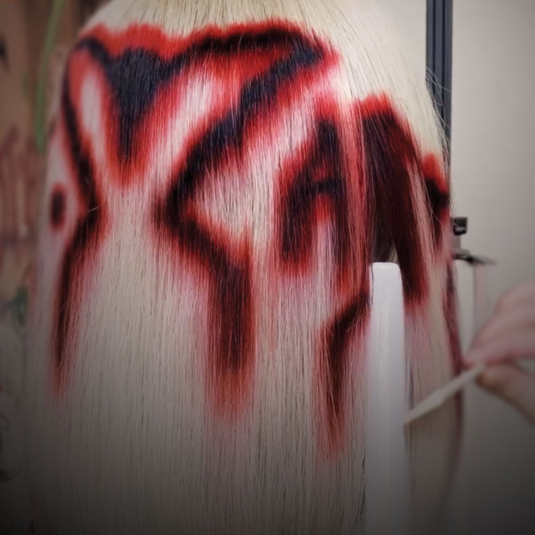 a hand combing a white red and black wig on a wig stand