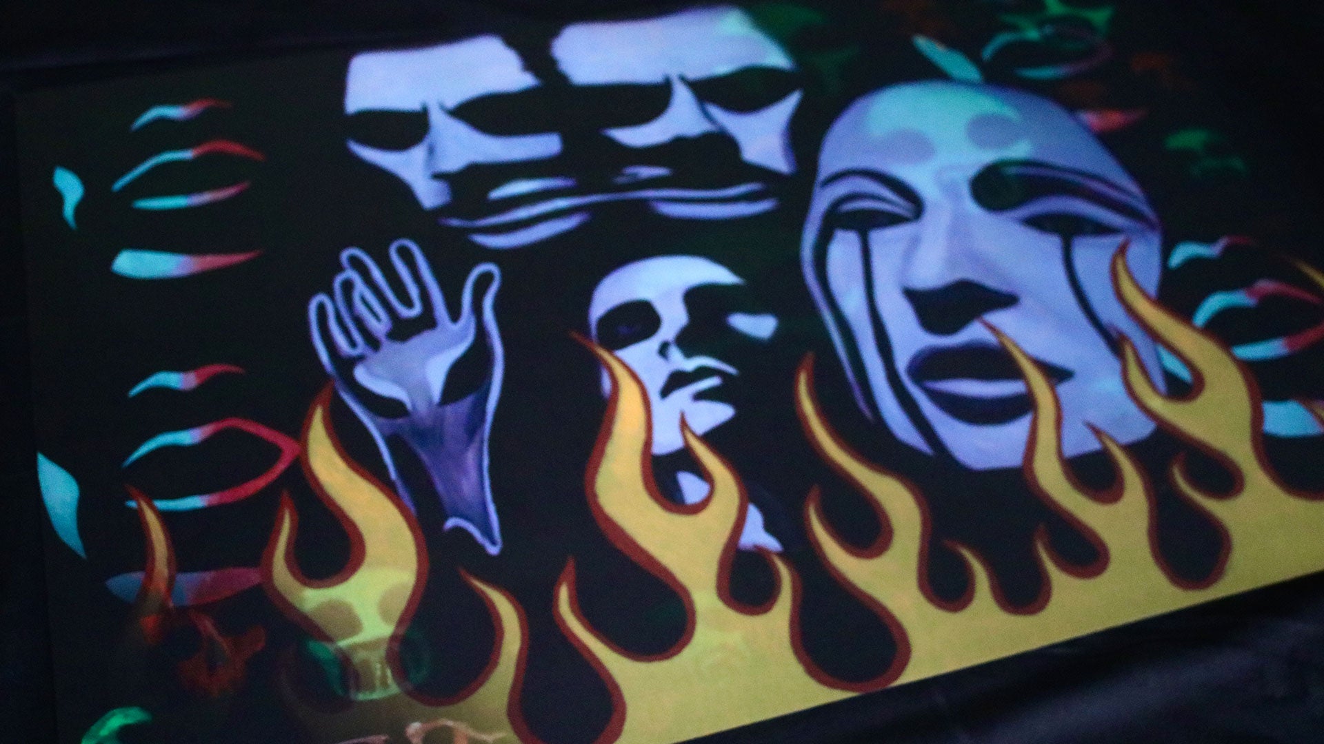 a lenticular print where the images switch between skull wig paintings and flames with mother mary imagery