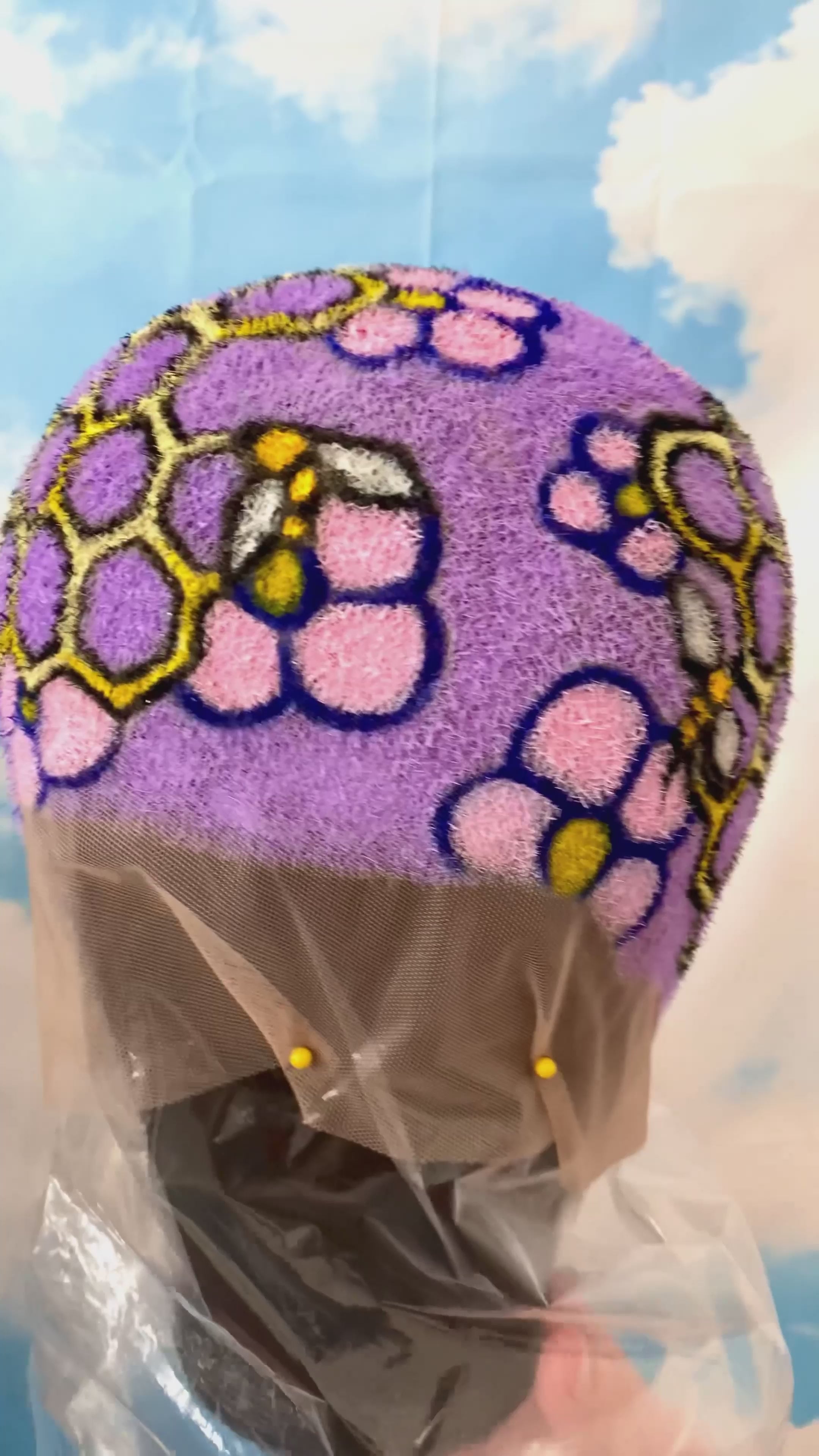 a video of a buzzed wig painted in purple with honeycomb and bees painted on it