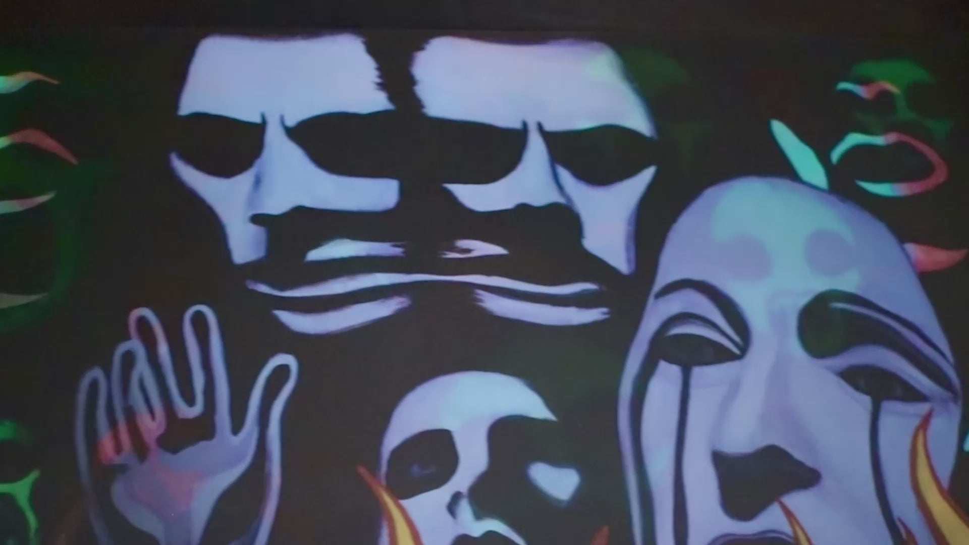 video panning a lenticular print where the images switch between skull wig paintings and flames with mother mary imagery