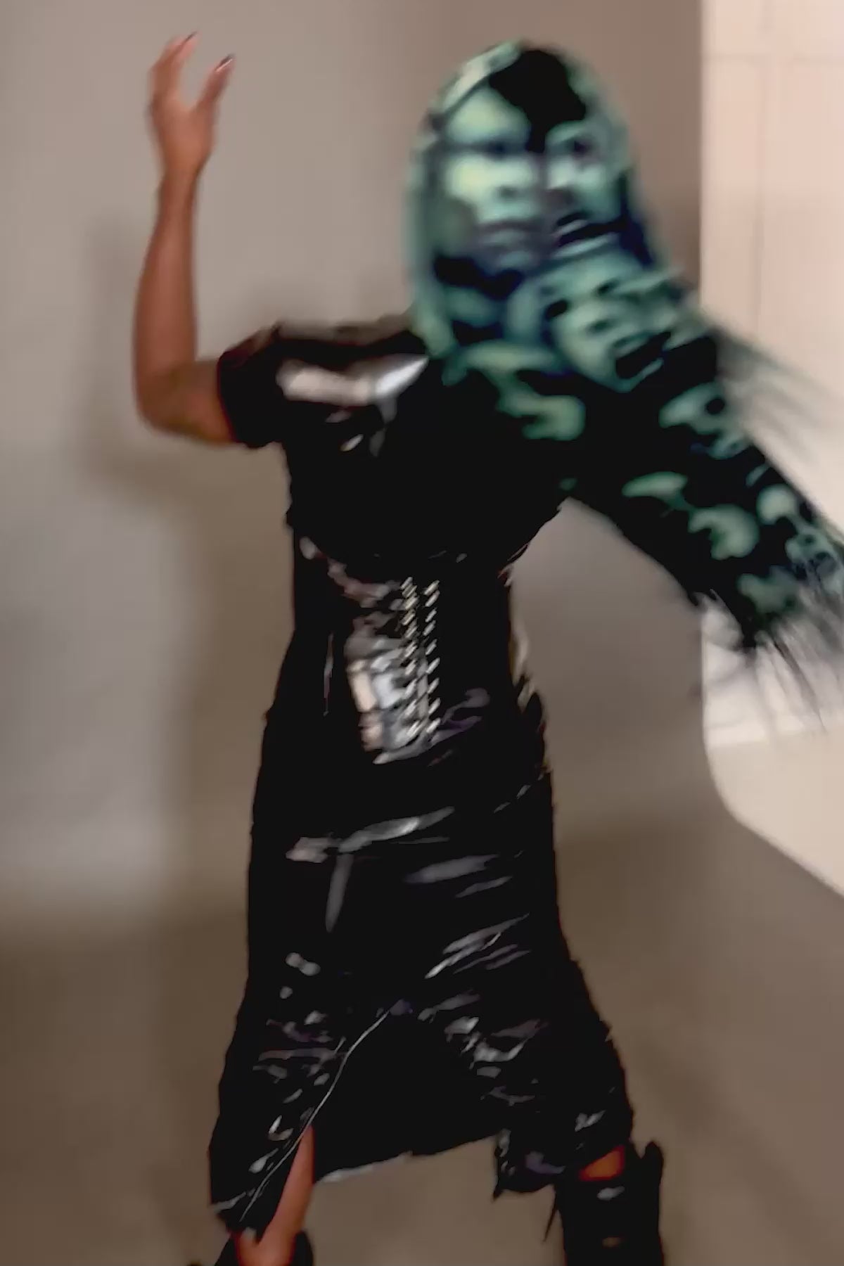 a video of a model wearing a blue black and white ghost face wig, shaking their head so the wig moves