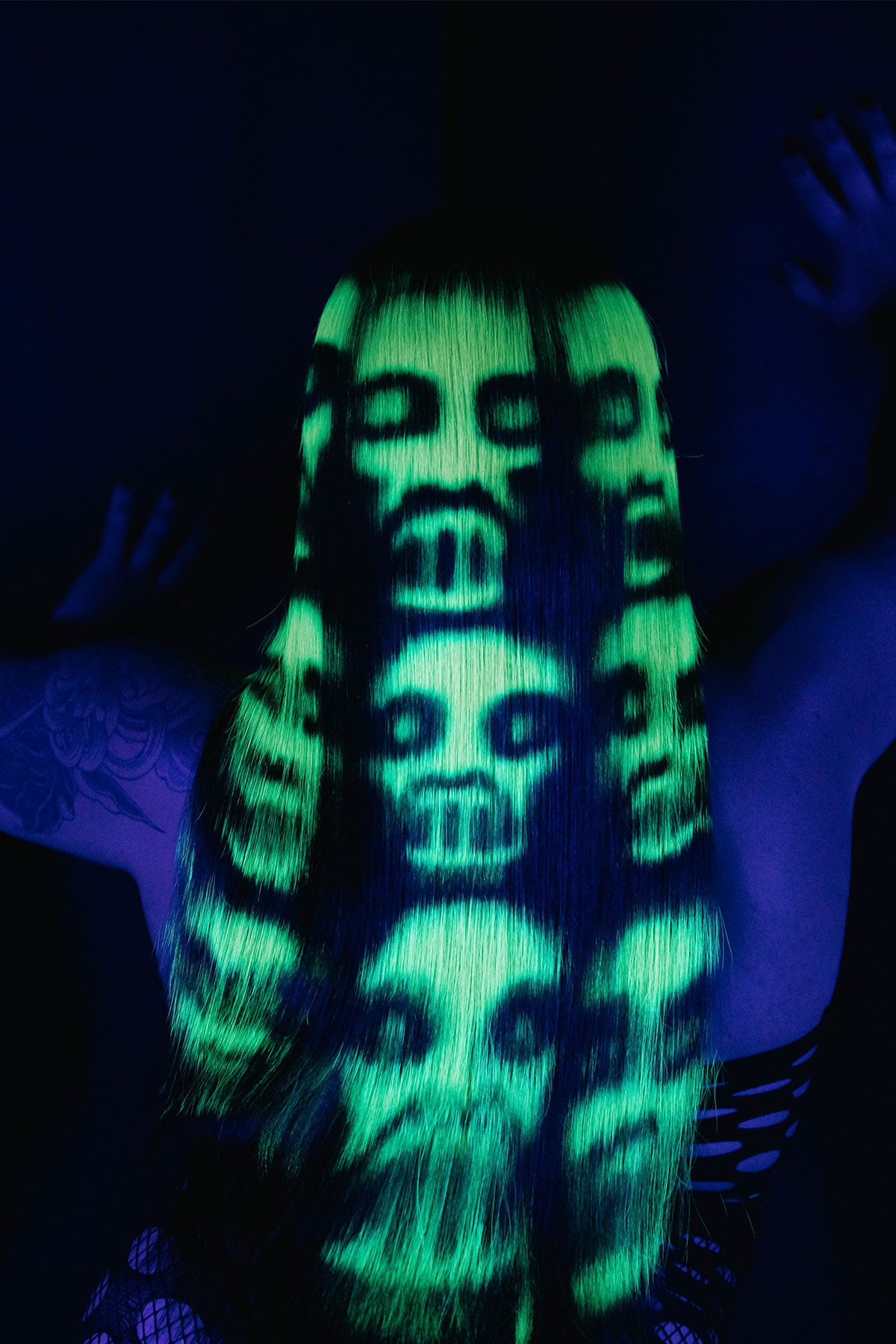 a back view of a model wearing a black and green zombie wig under black light
